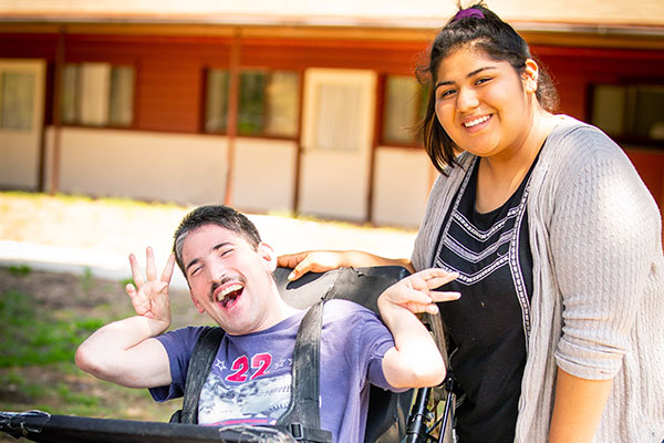 Young woman with male resident in wheelchair laughing